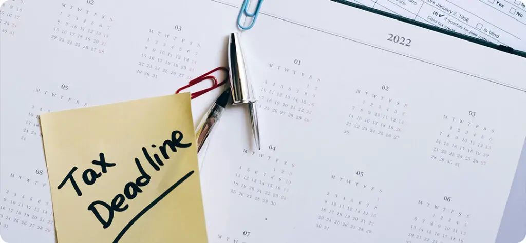 A calendar with tax deadlines highlighted, emphasizing the importance of filing on time