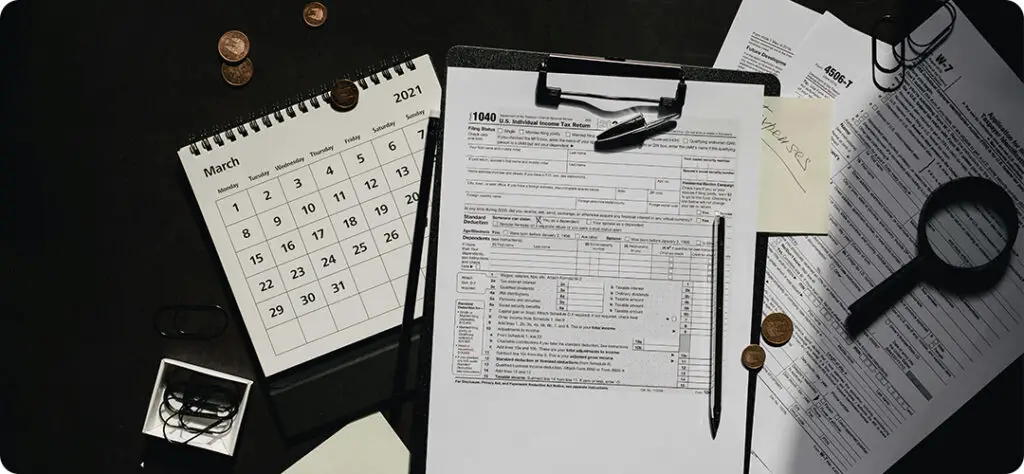 Tax documents and a calculator on a desk, symbolizing accurate income reporting