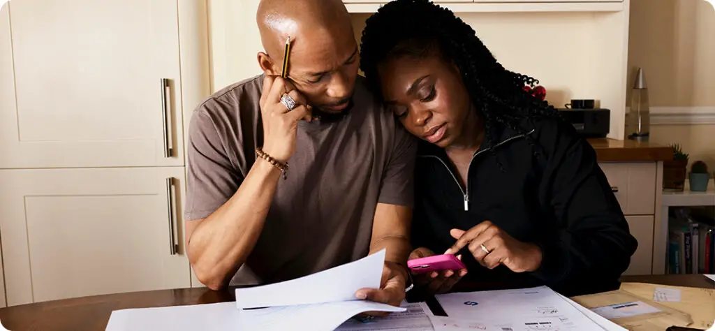 A family sitting together, reviewing documents to highlight the importance of term life insurance