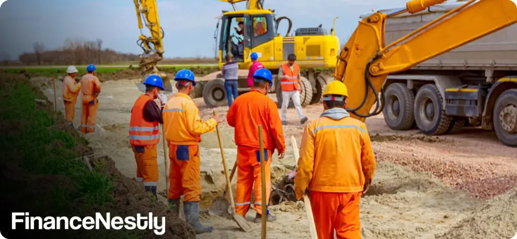 Construction workers operating heavy machinery on a large commercial site, symbolizing industry resilience amidst hiring slowdowns